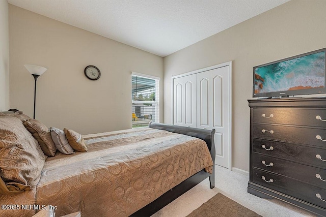 bedroom featuring light colored carpet and a closet