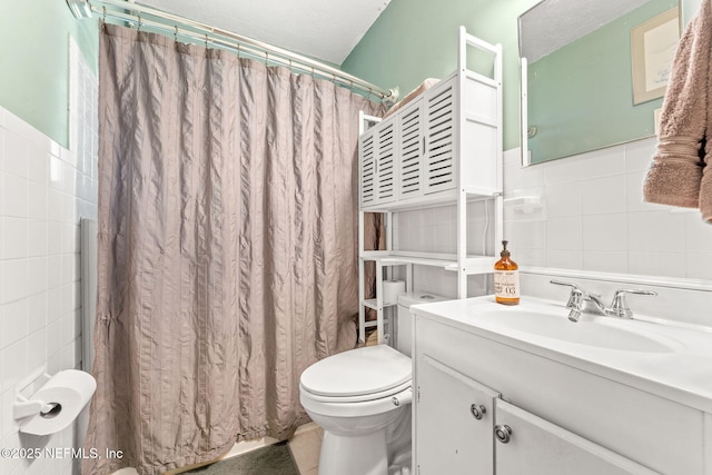 bathroom with a textured ceiling, vanity, tile walls, toilet, and a shower with shower curtain