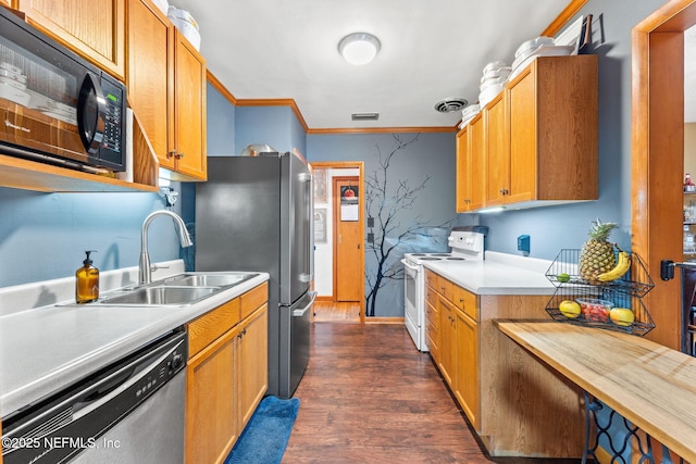 kitchen with dark wood-type flooring, appliances with stainless steel finishes, sink, and ornamental molding