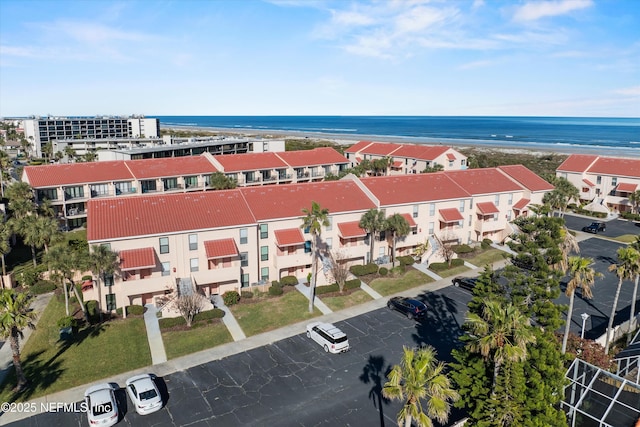 drone / aerial view featuring a water view and a view of the beach