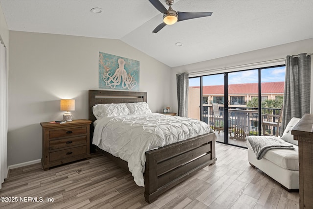 bedroom featuring ceiling fan, hardwood / wood-style flooring, access to outside, and lofted ceiling