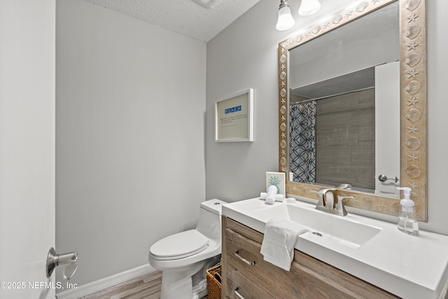 bathroom featuring toilet, vanity, wood-type flooring, a textured ceiling, and a shower with shower curtain