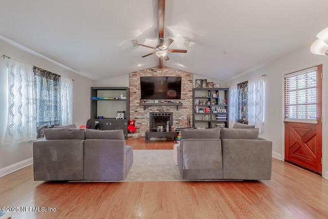 living room featuring light hardwood / wood-style floors, lofted ceiling, ceiling fan, and a fireplace