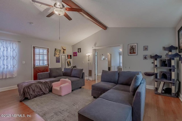 living room featuring ceiling fan, lofted ceiling with beams, and hardwood / wood-style flooring