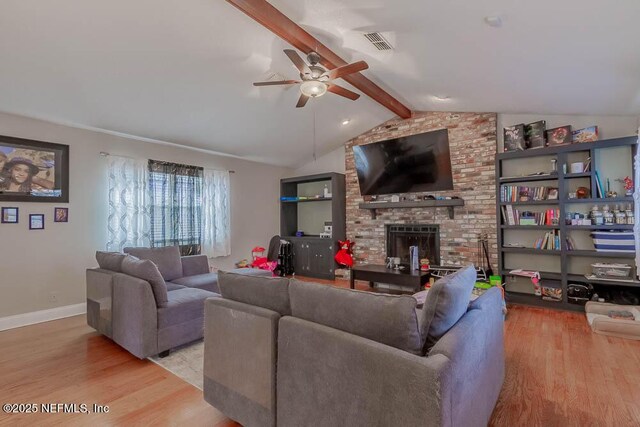 living room featuring a brick fireplace, light hardwood / wood-style flooring, lofted ceiling with beams, and ceiling fan