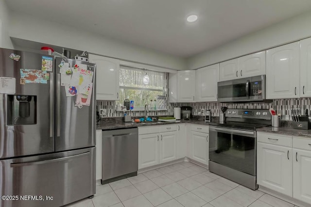 kitchen featuring decorative backsplash, sink, white cabinets, and stainless steel appliances