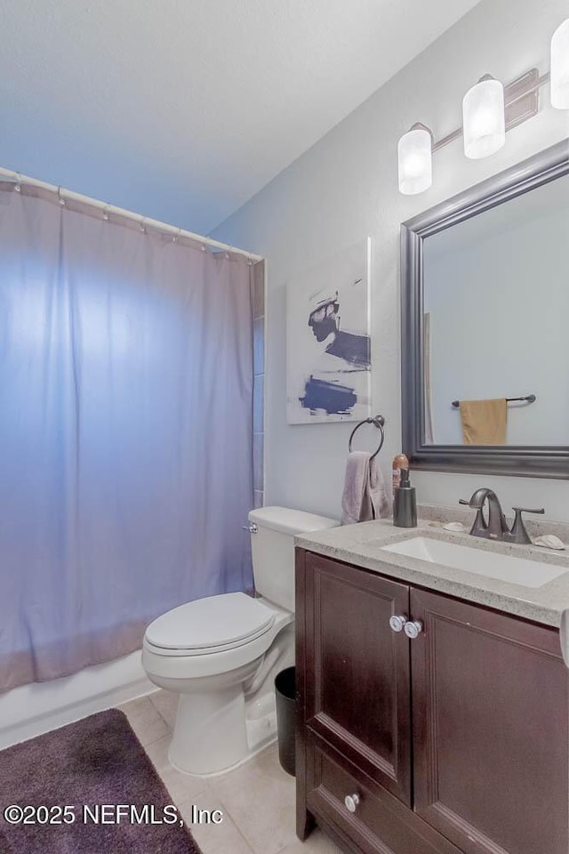 bathroom with toilet, tile patterned floors, and vanity