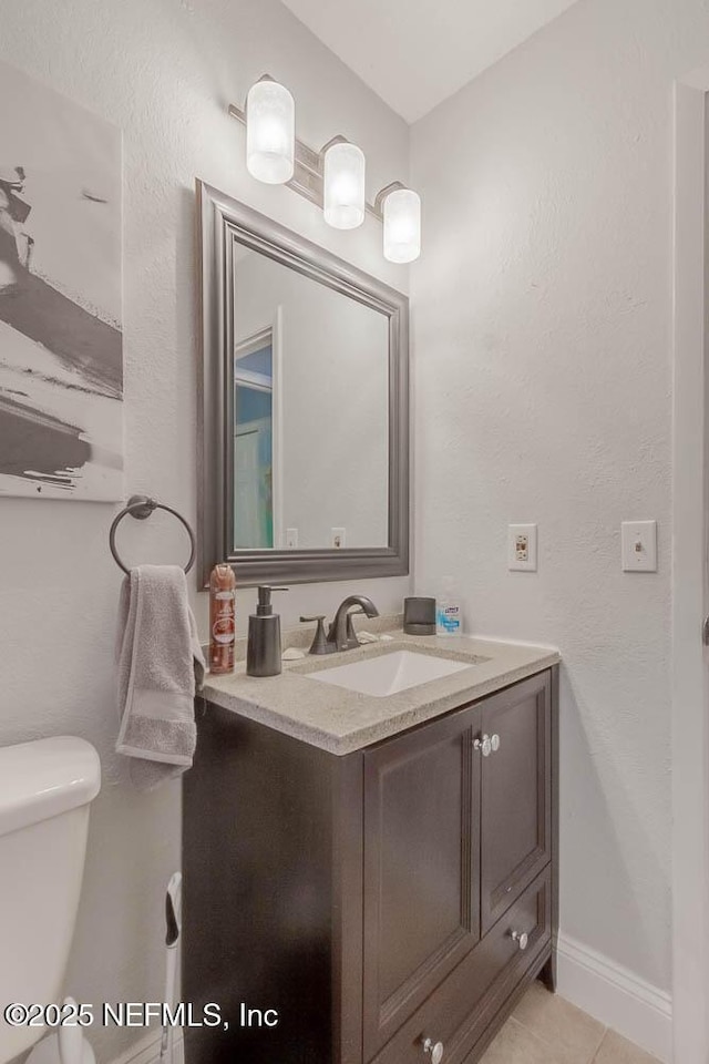 bathroom with tile patterned floors, vanity, and toilet