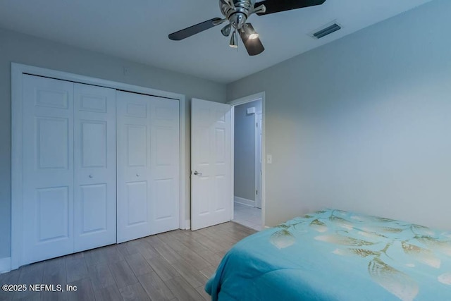 bedroom featuring ceiling fan, a closet, and hardwood / wood-style floors