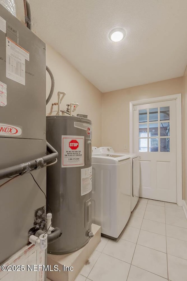 laundry area featuring a textured ceiling, independent washer and dryer, water heater, and light tile patterned flooring