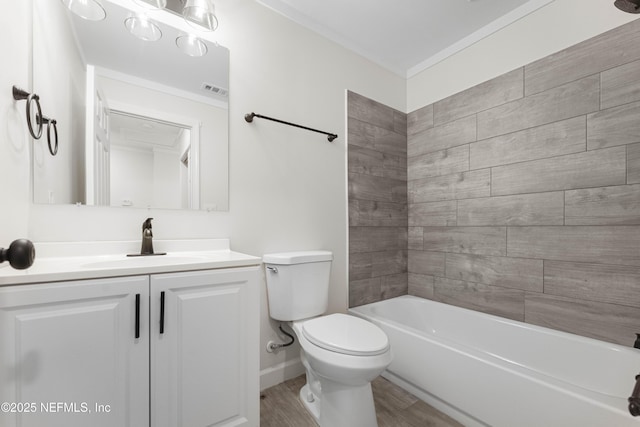 full bathroom featuring toilet, vanity, hardwood / wood-style floors, tiled shower / bath combo, and crown molding