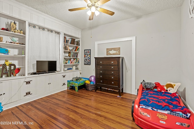 bedroom featuring ceiling fan, wood-type flooring, and a textured ceiling