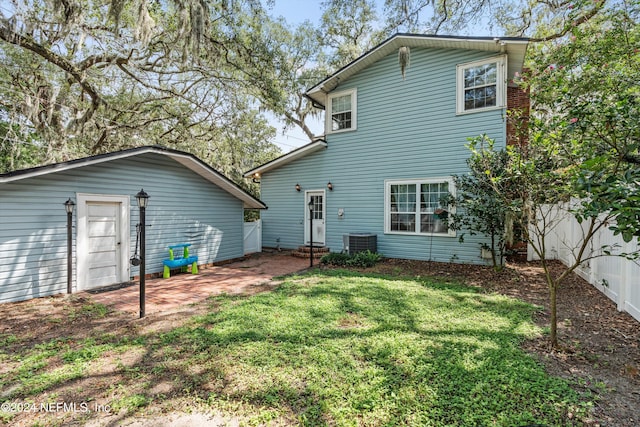 back of house featuring cooling unit and a yard