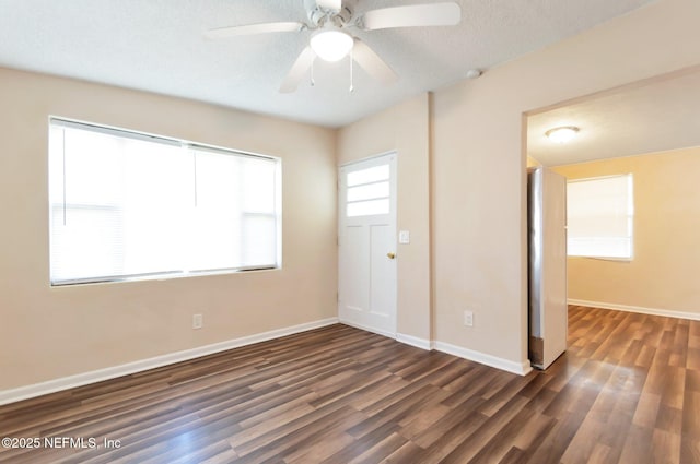 unfurnished room with ceiling fan, a textured ceiling, and dark hardwood / wood-style flooring