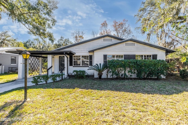 ranch-style home featuring a front lawn and a carport