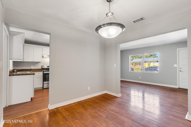 unfurnished living room with sink and hardwood / wood-style flooring