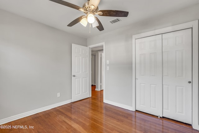 unfurnished bedroom with a closet, ceiling fan, and wood-type flooring