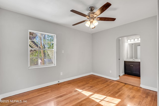 unfurnished bedroom with light hardwood / wood-style flooring, ceiling fan, and ensuite bathroom