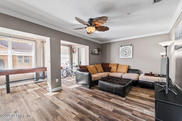 living room featuring a textured ceiling, crown molding, and wood-type flooring