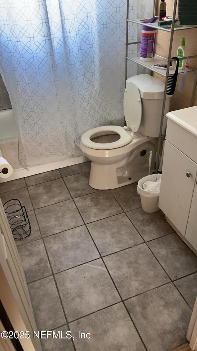 bathroom with toilet, vanity, tile patterned floors, and walk in shower