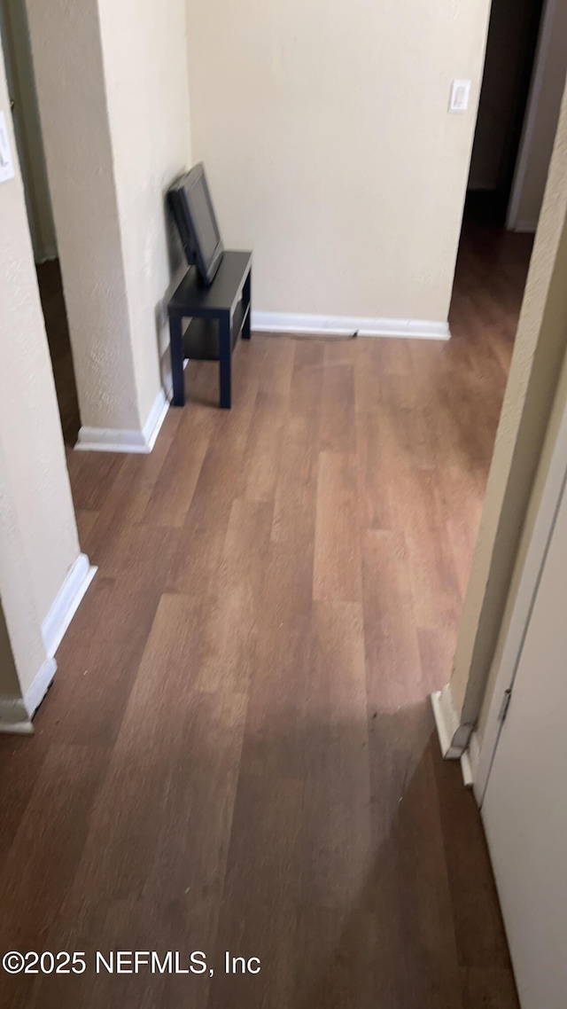 corridor with dark hardwood / wood-style flooring