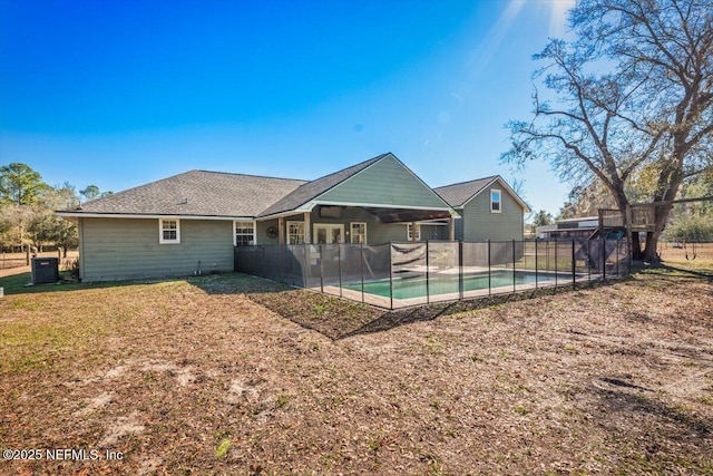 back of house with a fenced in pool, a lawn, cooling unit, and a patio