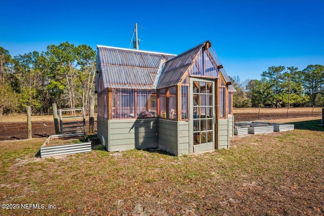 back of property with a lawn and an outdoor structure