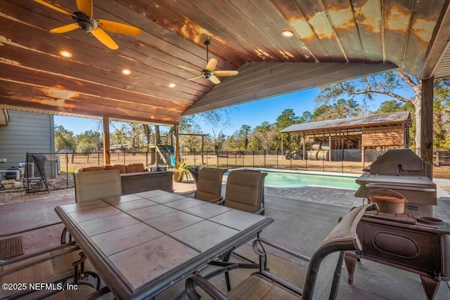 view of patio / terrace with ceiling fan and a fenced in pool