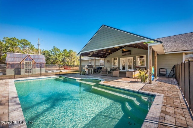 view of swimming pool with ceiling fan, a patio, and grilling area