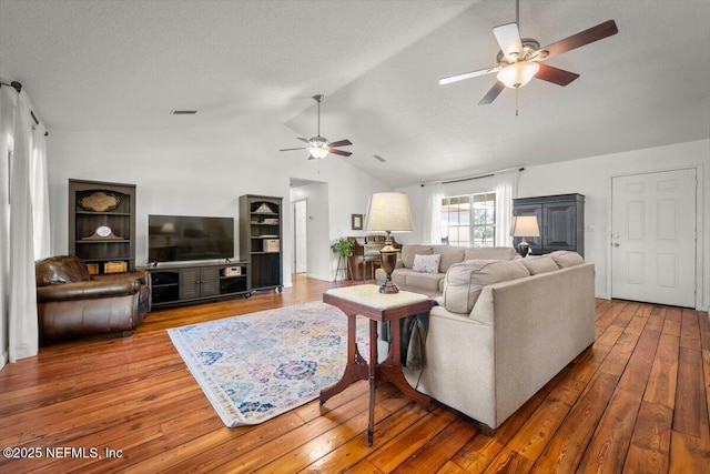 living room with vaulted ceiling, ceiling fan, a textured ceiling, and hardwood / wood-style flooring