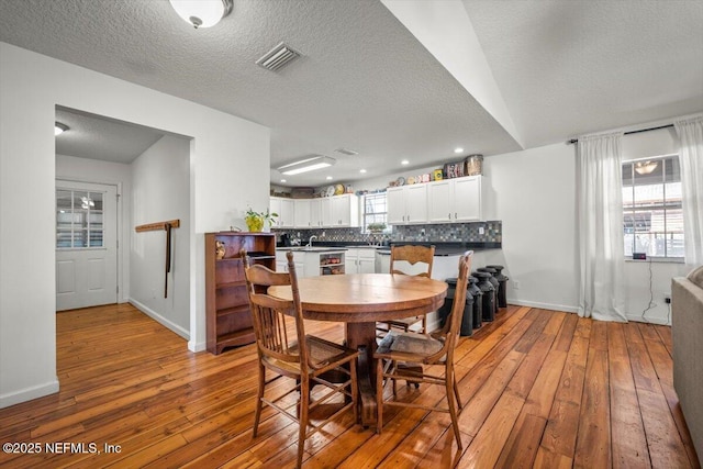 dining room with a textured ceiling and light hardwood / wood-style flooring