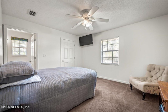 bedroom with ceiling fan, carpet floors, and a textured ceiling