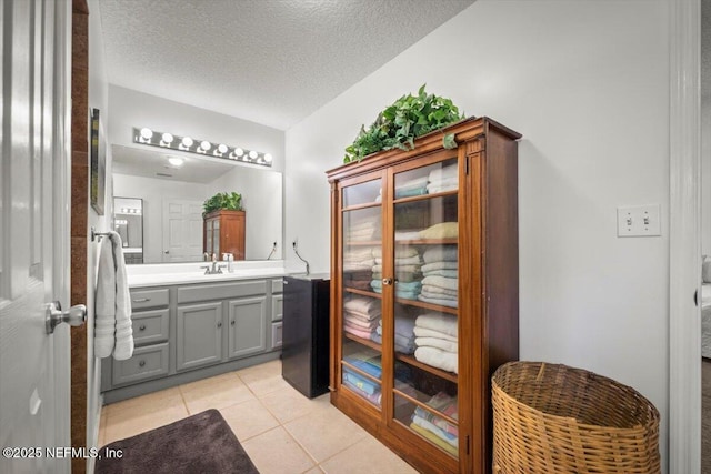 bathroom with a textured ceiling, tile patterned flooring, and vanity