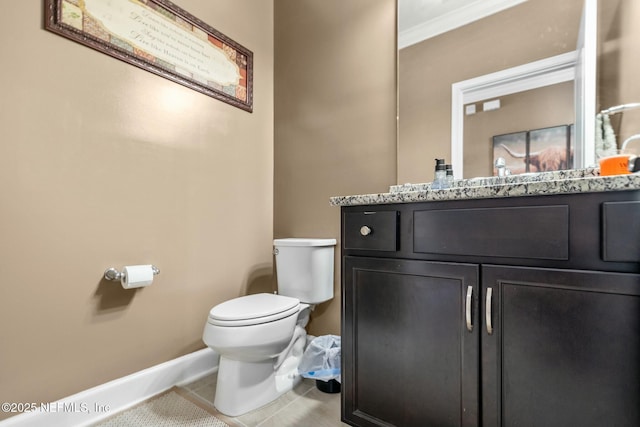 bathroom featuring toilet, vanity, tile patterned flooring, and ornamental molding