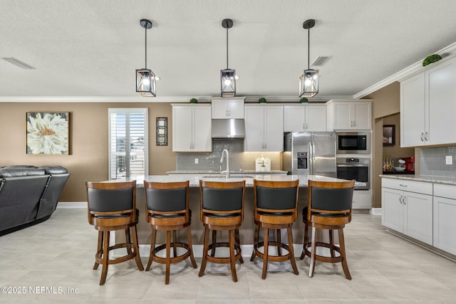 kitchen featuring backsplash, light stone counters, stainless steel appliances, and pendant lighting