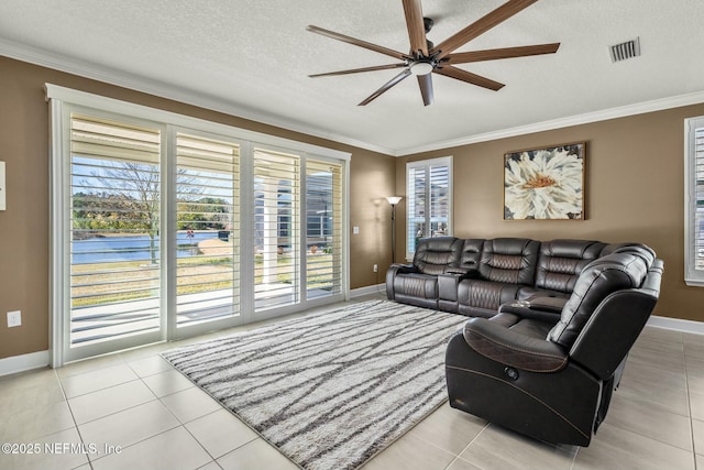 living room with a textured ceiling, ceiling fan, light tile patterned flooring, and crown molding