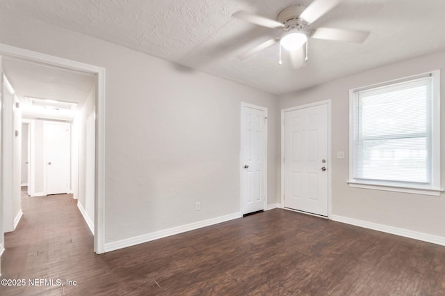 empty room featuring a textured ceiling, ceiling fan, and dark hardwood / wood-style floors