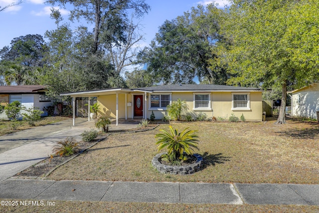 ranch-style house featuring a front lawn and a carport