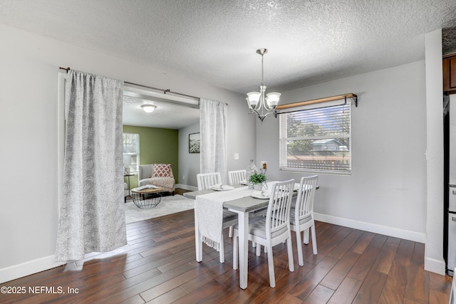 dining space featuring dark wood-type flooring, a notable chandelier, and a textured ceiling