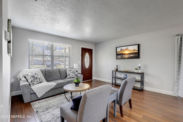 living room featuring wood-type flooring and a textured ceiling