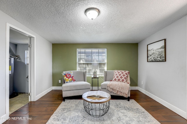 sitting room with dark hardwood / wood-style floors and a textured ceiling