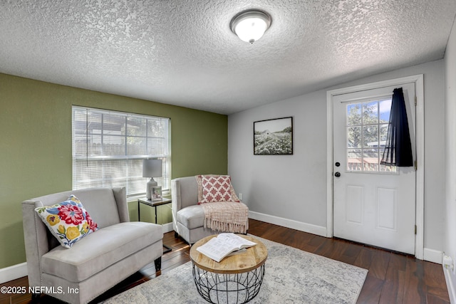 sitting room with dark wood-type flooring and a textured ceiling