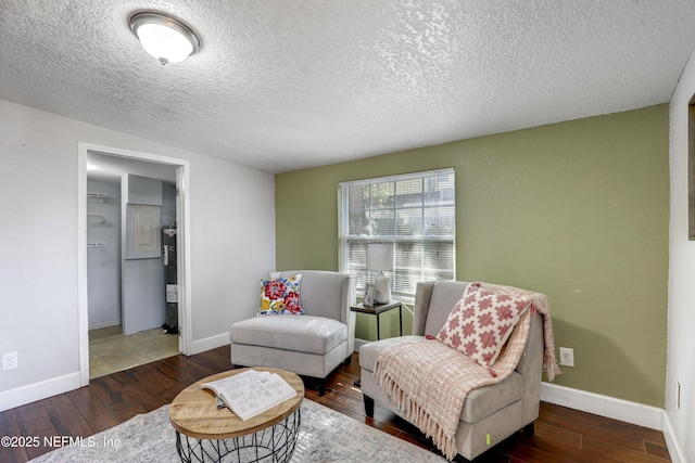 living area with dark hardwood / wood-style flooring, water heater, and a textured ceiling