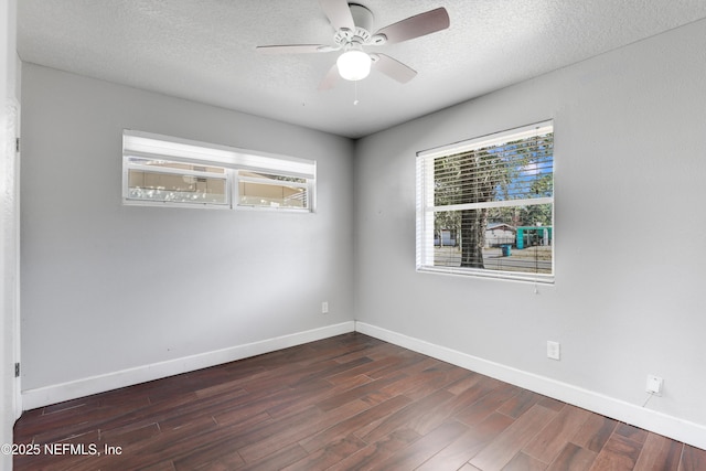 empty room with dark wood-type flooring, ceiling fan, and a textured ceiling