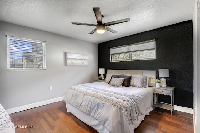 bedroom with ceiling fan, dark hardwood / wood-style floors, and a textured ceiling