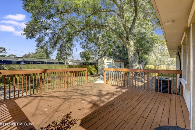 wooden terrace with central air condition unit and a storage shed