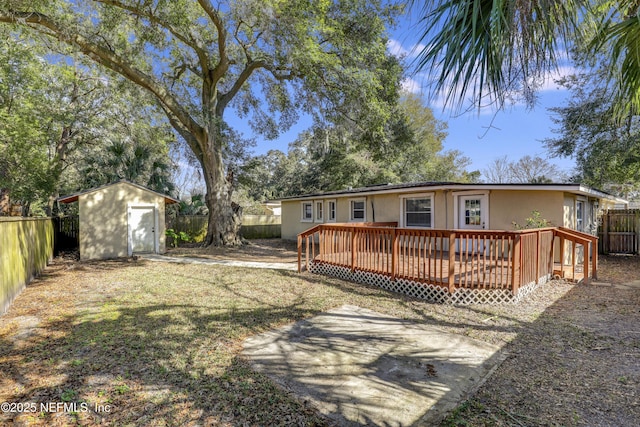 rear view of property with a shed and a deck