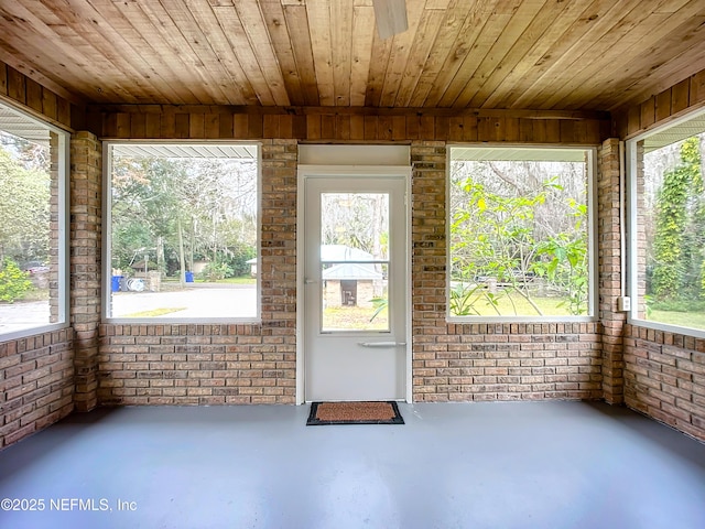 unfurnished sunroom featuring wooden ceiling and plenty of natural light