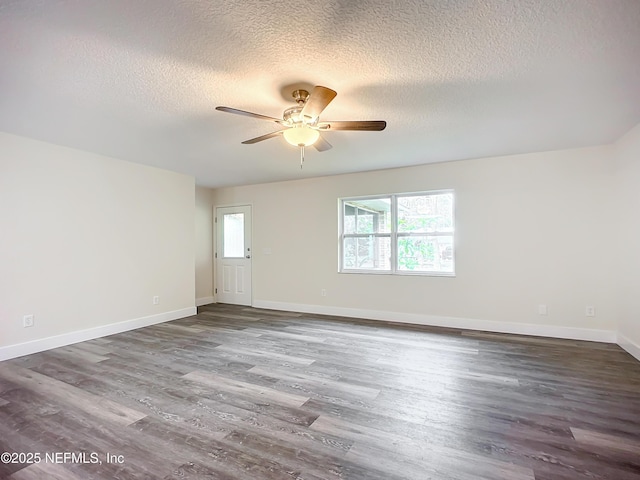 empty room with ceiling fan, dark hardwood / wood-style flooring, and a textured ceiling