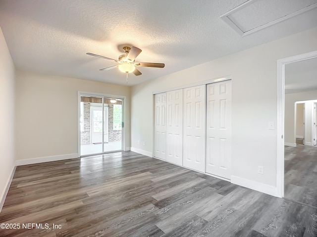 unfurnished bedroom featuring ceiling fan, dark wood-type flooring, a textured ceiling, and access to exterior